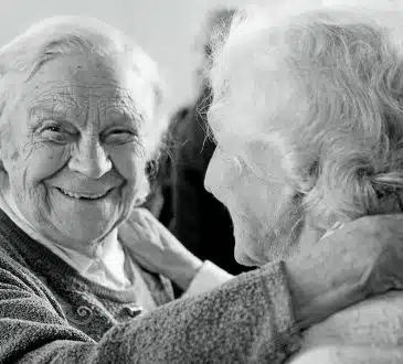 grayscale photo of woman in sweater smiling