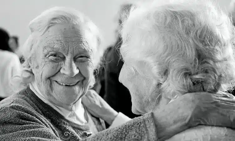 grayscale photo of woman in sweater smiling