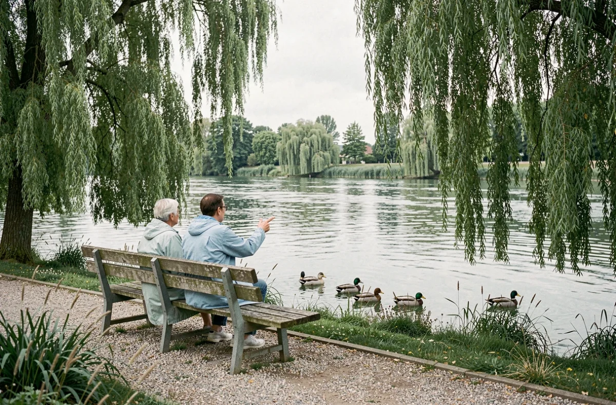 Résidente et soignante assises sur un banc face à la rivière Oise dans le jardin de la Résidence Les Bords de l'Oise